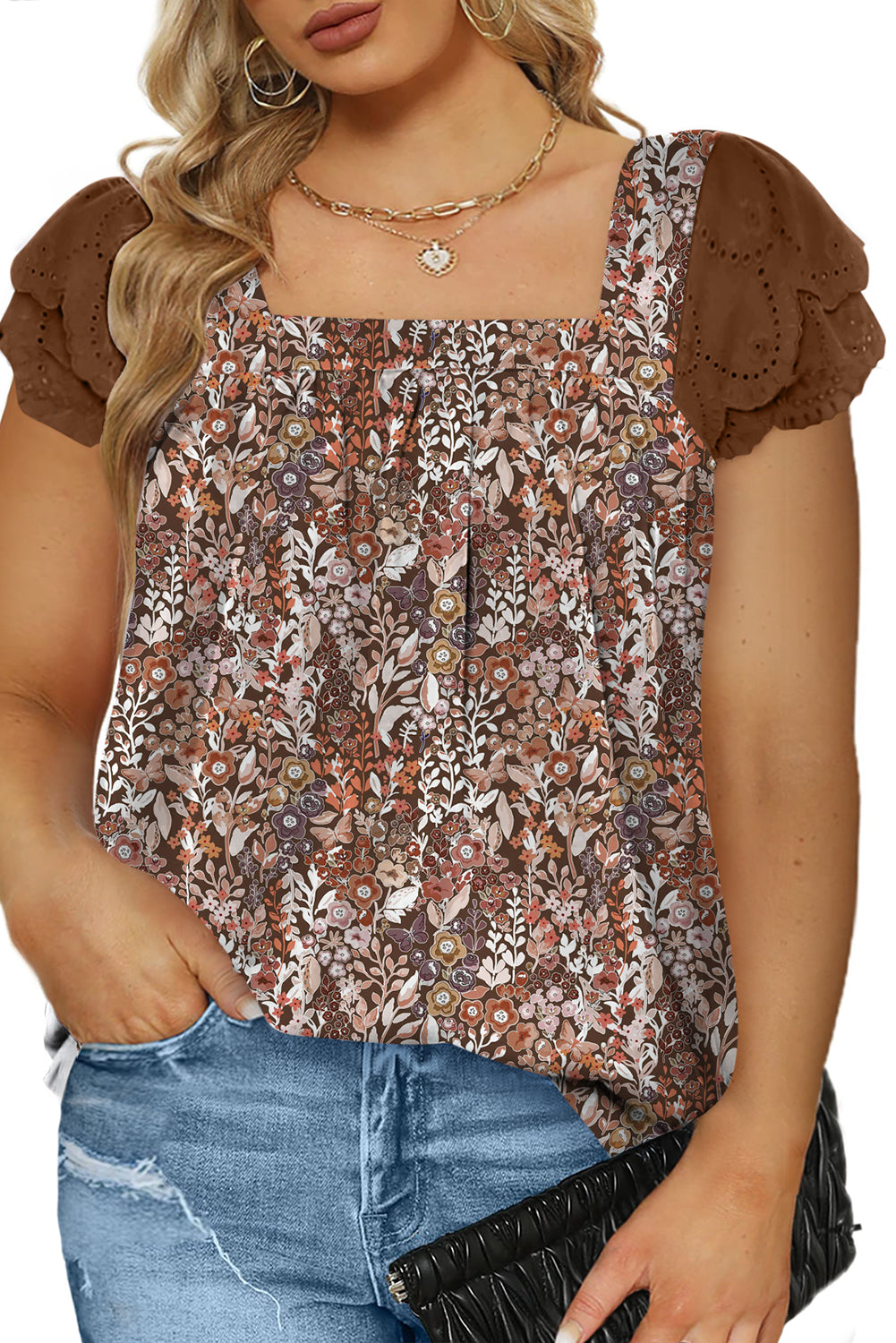 Woman wearing a floral blouse with brown sleeves and blue jeans on a white background