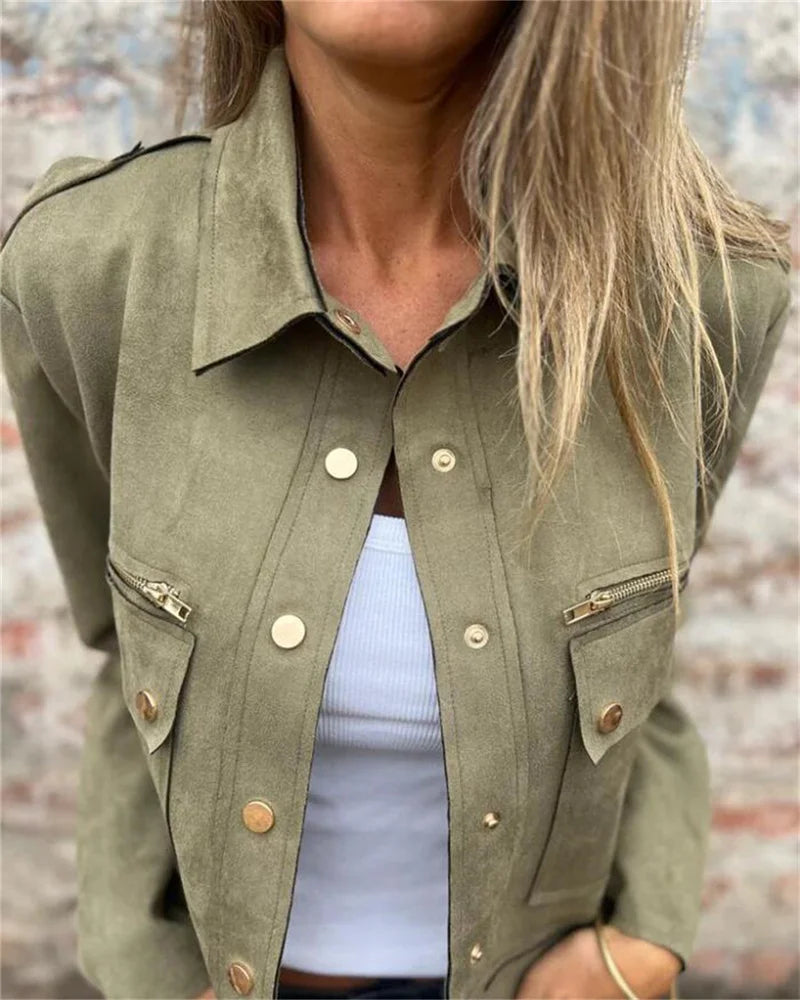 Green jacket with buttons and zippers worn by a person, blurred background
