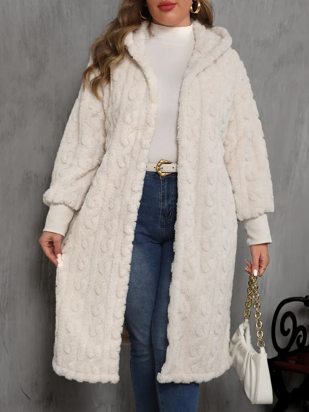 Woman wearing a long creamy white micro fleece coat with a plain background