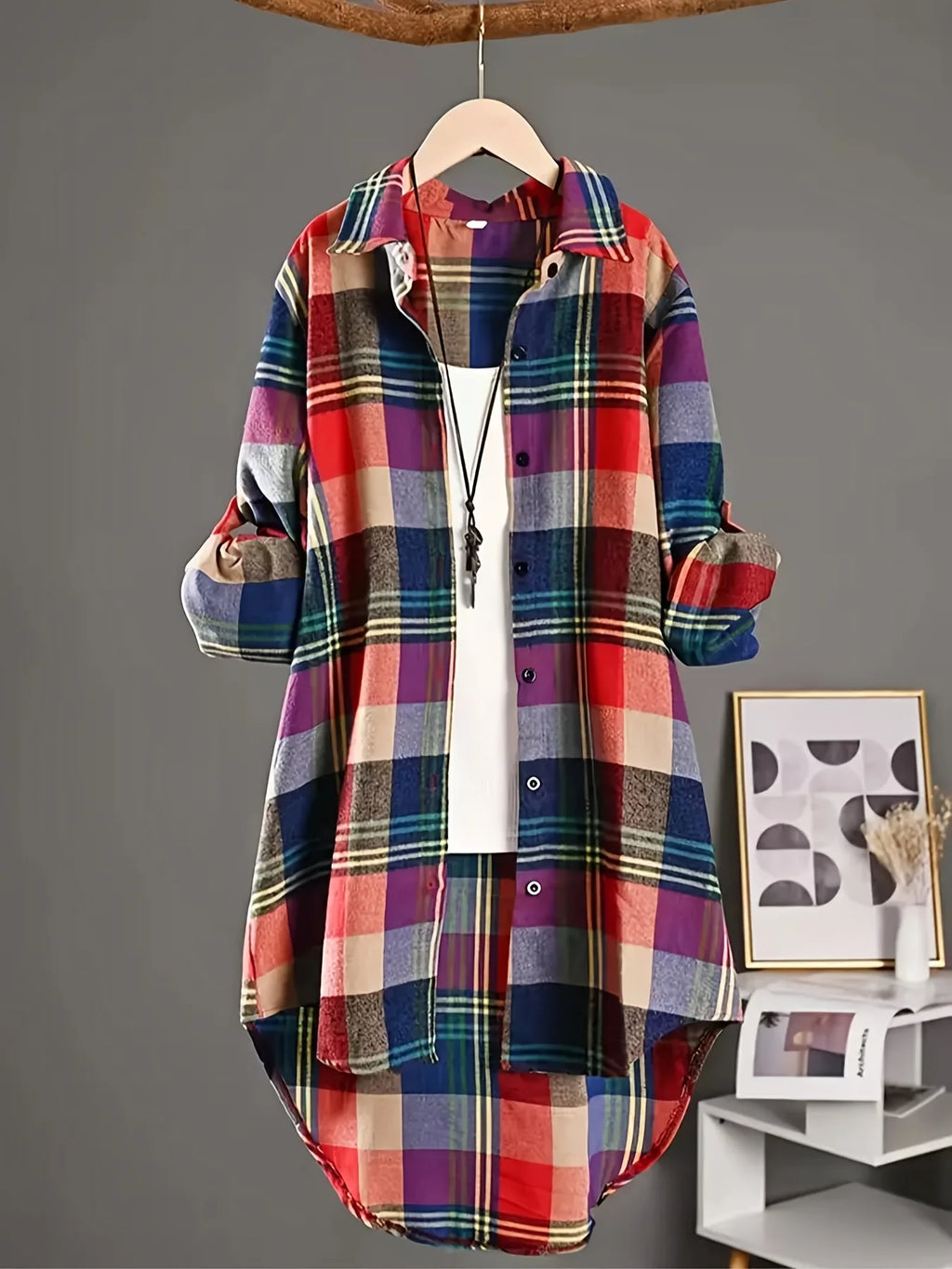 Colorful plaid shirt on a hanger against a gray background