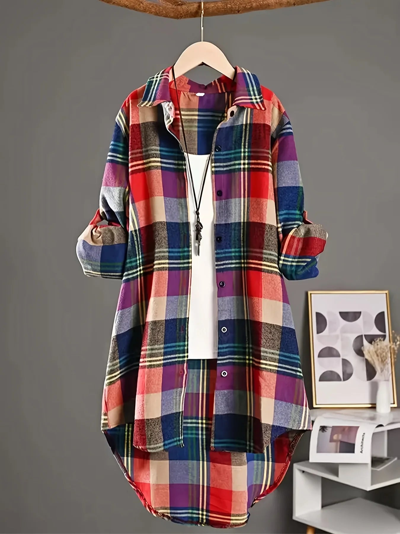 Colorful plaid shirt on a hanger against a gray background