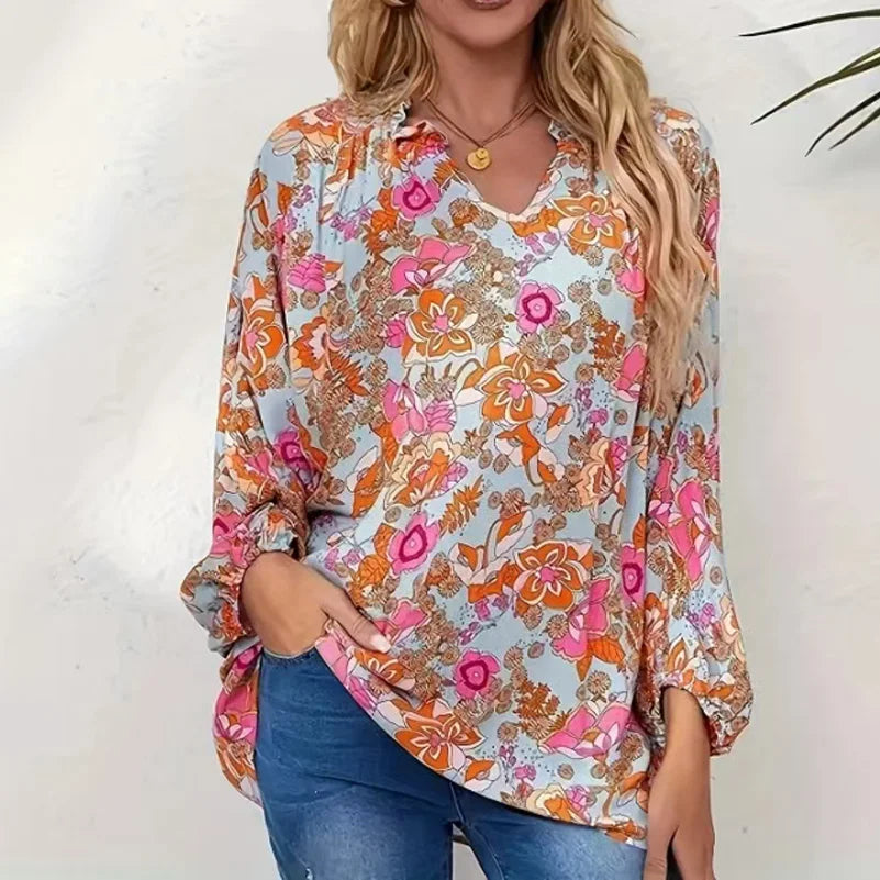 Woman wearing a colorful floral blouse against a white background