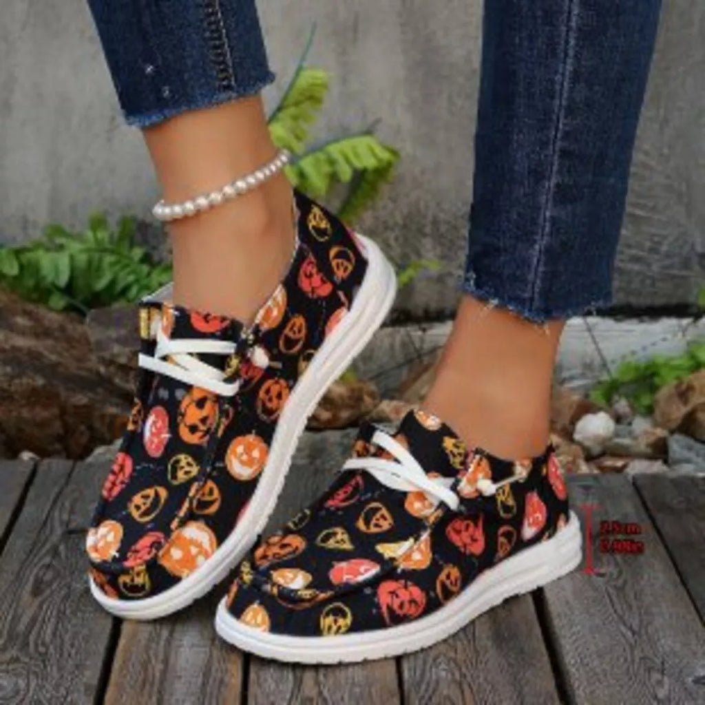 Halloween-themed sneakers with pumpkins on a wooden surface.